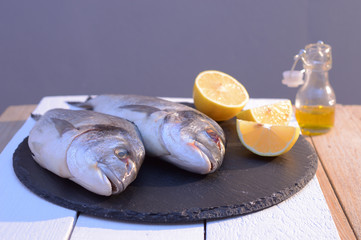 dorado fish on a black plate with lemon