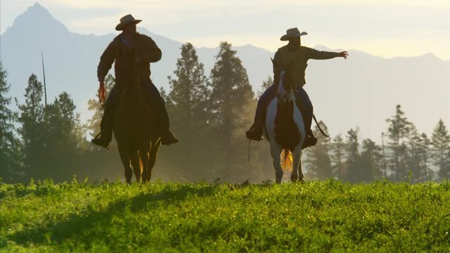 Cowboy Riders galloping forest wilderness area Canada