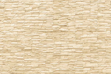 Rock stone brick tile wall aged texture detailed pattern background in yellow cream beige color