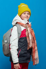 school girl with backpack wearing winter knitted hat