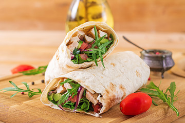 Tortillas wraps with chicken and vegetables on  wooden background. Chicken burrito. Healthy food.