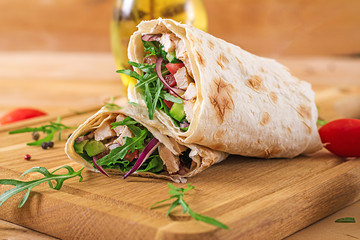 Tortillas wraps with chicken and vegetables on  wooden background. Chicken burrito. Healthy food. - obrazy, fototapety, plakaty