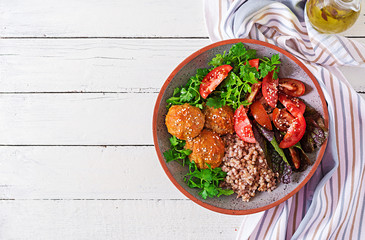 Meatballs, salad of tomatoes and buckwheat porridge on white wooden table. Healthy food. Diet meal. Buddha bowl. Top view. Flat lay
