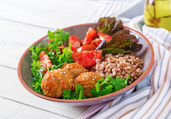 Meatballs, salad of tomatoes and buckwheat porridge on white wooden table. Healthy food. Diet meal. Buddha bowl.
