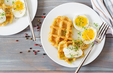 Healthy breakfast or snack. Potato waffles and boiled egg on grey wooden table. Top view. Flat lay