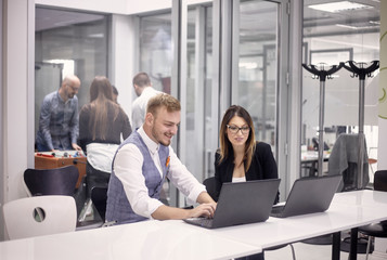 group of people, working on laptop, some relaxing having fun playing table football, indoors modern office building.