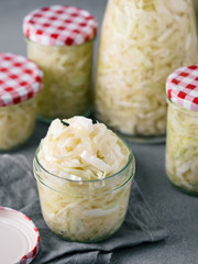 Sauerkraut in open glass mason jar. Pickling cabbage at home on table. The best natural probiotic....