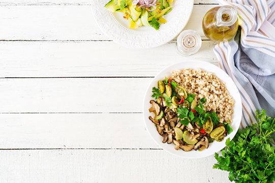 Diet menu. Healthy vegetarian meal - mushrooms shiitake, zucchini  and oatmeal porridge on bowl. Vegan food. Flat lay. Top view