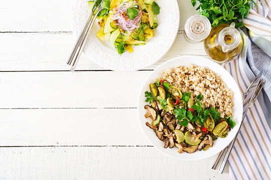 Diet menu. Healthy vegetarian meal - mushrooms shiitake, zucchini  and oatmeal porridge on bowl. Vegan food. Flat lay. Top view