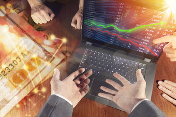Stock market investment concept gain and profits with candlestick charts and numbers while financial business team debates and meets to discuss.