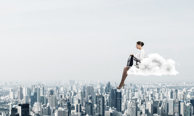 Fototapeta na wymiar Businesswoman or accountant on cloud floating high above modern 