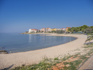 Fototapeta na wymiar Beautiful sandy beach at Adriatic sea with lots of apartment buildings.