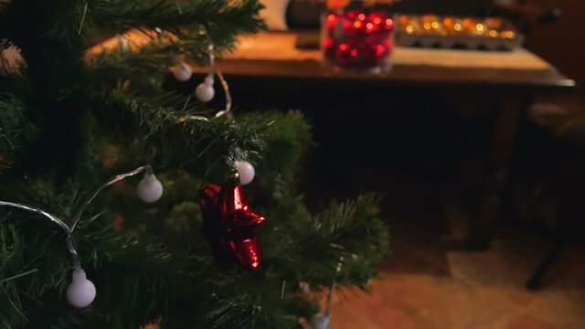 Little girl decorating christmas tree with color lights and shiny bulbs. Family time filmed in slow motion hd.
