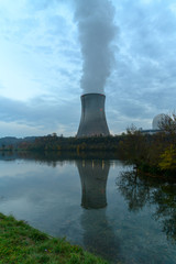 looking over a river at an atomic reactor cooling tower
