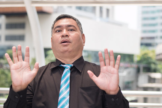 Scared Business Man Saying No. Portrait Of Excited, Scared Asian Businessman Showing Stop, Halt Hand Gesture With Fear. 50s Old Southeast Asian Man Model