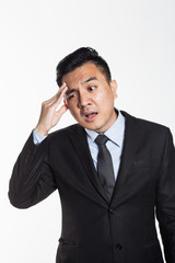 Asian man in business suit having headache