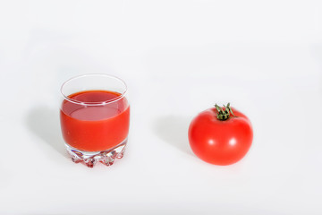 tomato juice in a glass and tomato on white background