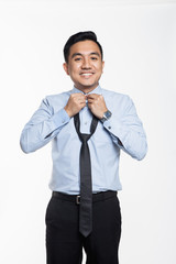 Asian businessman fixing his neck tie