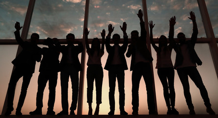silhouette of a group of business people raising their hand