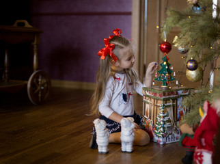 girl decorates Christmas tree at home