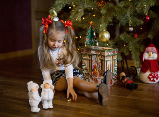 girl decorates Christmas tree at home