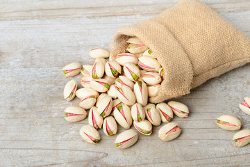 pistachio nuts with shell in the sack, on the wooden board