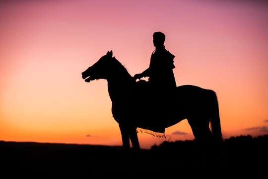 Horses and Men Silhouette at Sunset on a High Mountain