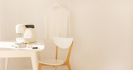 Workplace for sewing and needlework in a bright room with white furniture.