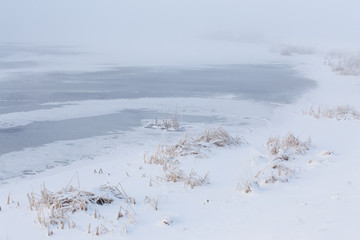 winter landscape with a picture of a frozen lake covered with snow on a cold winter day just before Christmas