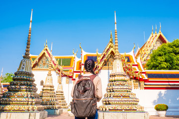 Asian women backpack tourist is relax travel in holiday at wat pho Bangkok Thailand. It is a...