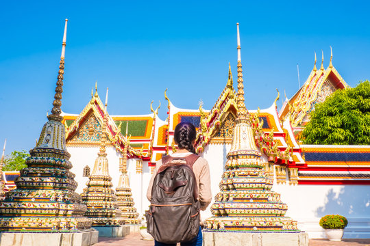 Asian women backpack tourist is relax travel in holiday at wat pho Bangkok Thailand. It is a landmark and attraction.