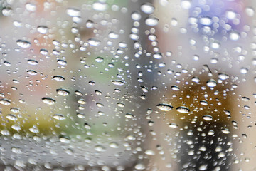 Background the glass of water is at the glass. The granularity is caused by falling rain.