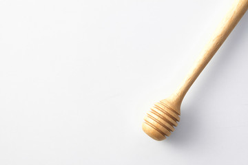 wooden honey drizzler on white