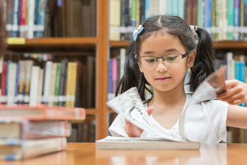 School education and literacy concept with Asian girl kid student learning and reading book in...