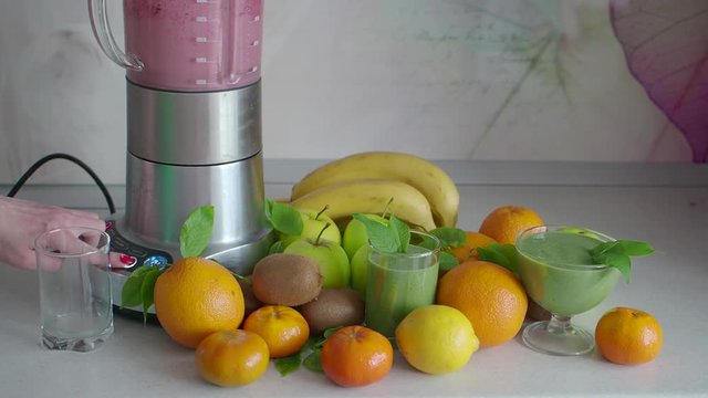 Green cocktail and smoothies with a blender on the kitchen table