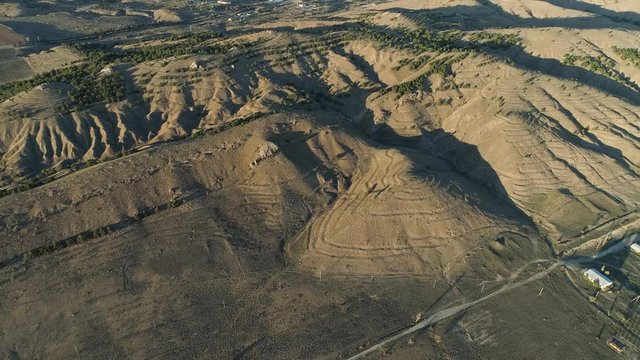 Top view of desert mountain ranges and town. Shot. Panorama of meager green hills and mountain horizon with sea shore