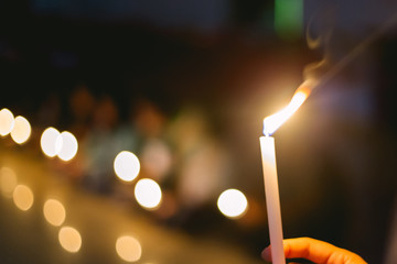 soft focus of people lighting candle vigil in darkness seeking hope, worship, prayer