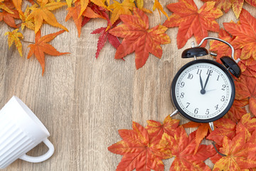 Old clock on autumn leaves