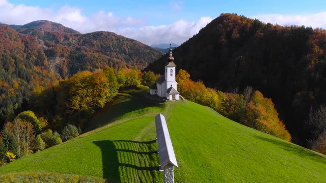 4K aerial drone footage flying around chapel in Danje,Slovenia with mountains in background