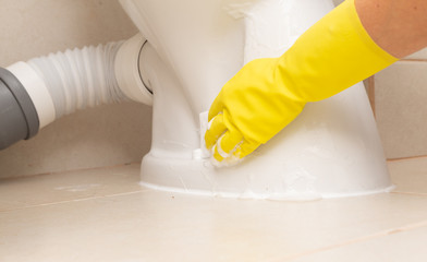 Person cleaning exterior of toilet.