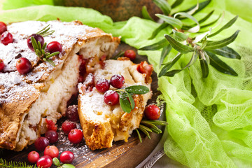 Delicious cranberry pie with fresh cranberries and herbs for Christmas on wooden plate