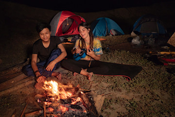 portrait couple camping, enjoy the night with guitar a sing a so