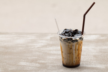 Grass jelly with fresh milk and caramel in plastic cup