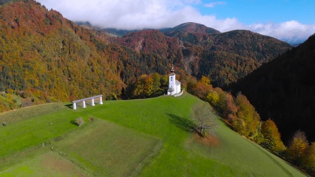 4K aerial drone footage flying around chapel in Danje,Slovenia with mountains in background