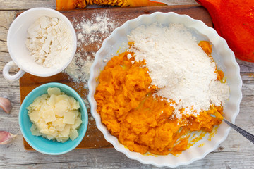 Ingredients on gnocchi with pumpkin on the kitchen wooden table.
