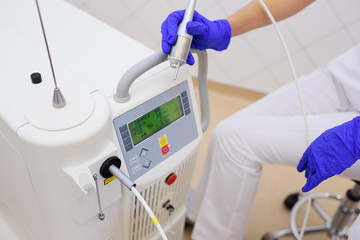 Cosmetologist doctor on the background of neodymium laser for cosmetic and dermatological...
