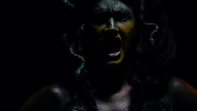 Medusa Gorgon screams while swinging her crossed swords