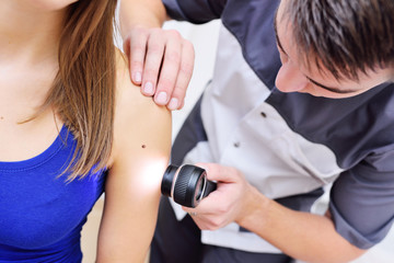 Naklejka premium dermatoscopy-a method of research and diagnosis of skin tumors - moles, birthmarks, nevi, warts, acne with a special optical device Dermatoscope.