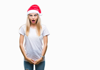 Young beautiful blonde woman christmas hat over isolated background afraid and shocked with surprise expression, fear and excited face.