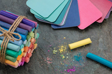 Palette of colors, rainbow pastel crayons and pigment dust on stone background. Matching of colors. Selective focus